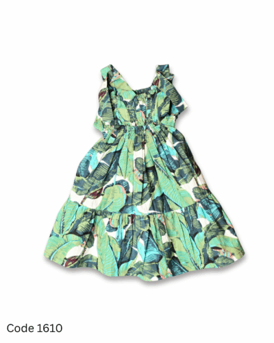 Girl wearing a green leaves print dress with tie-shoulder straps and elastic yoke
